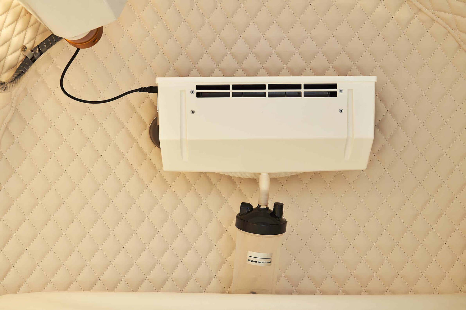 Back view of a hyperbaric oxygen chamber with connections and control panel displayed.