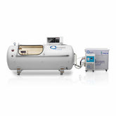 Back view of a hyperbaric oxygen chamber with connections and control panel displayed.